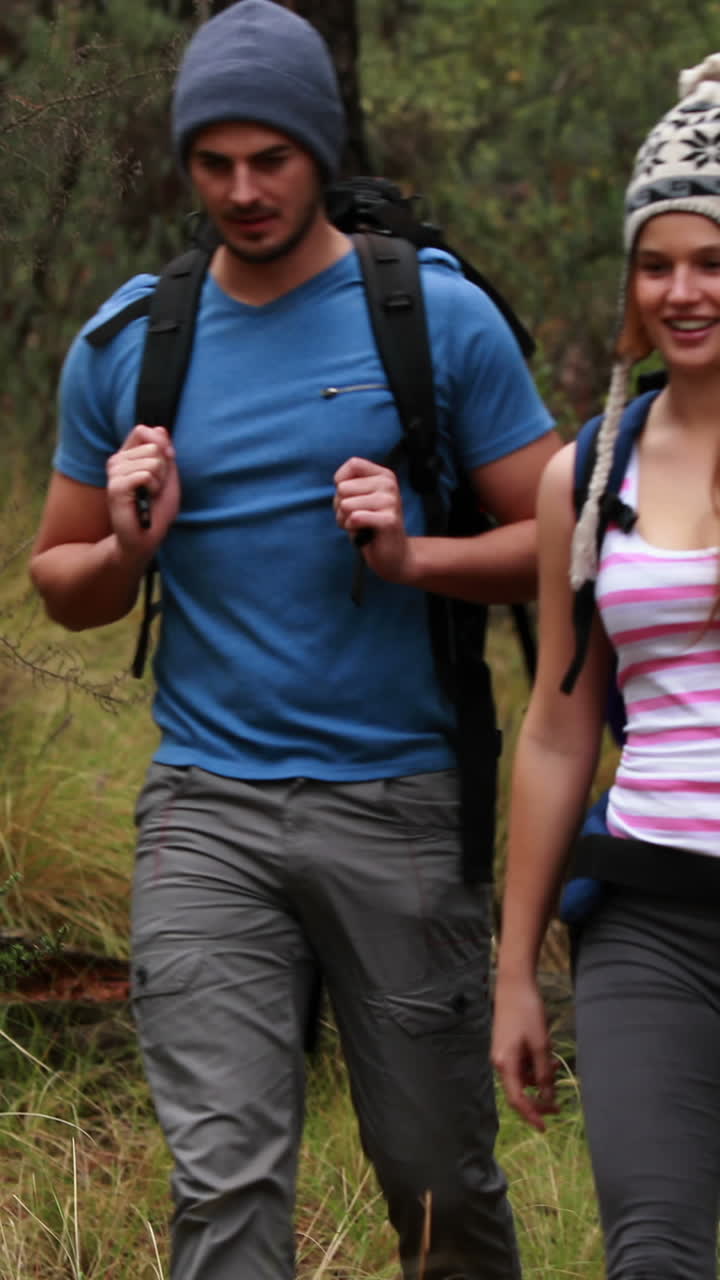 una pareja feliz haciendo senderismo y tomando un descanso.