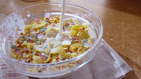 crispy yellow corn flakes into the bowl for the morning a delicious breakfast with milk. slow motion with rotation tracking shot.