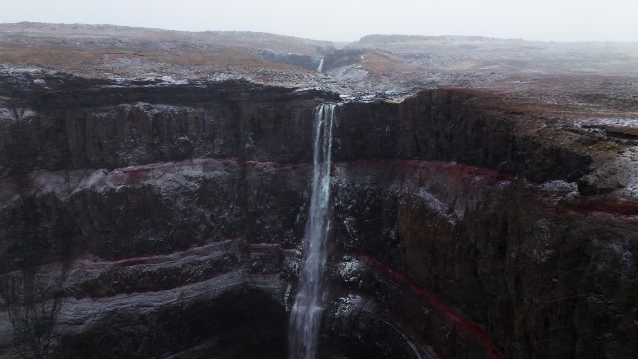 fotografía de avión no tripulado de la cascada de hengifoss en islandia durante las nevadas