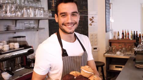 Portrait-of-smiling-waiter-standing-with-arms-crossed