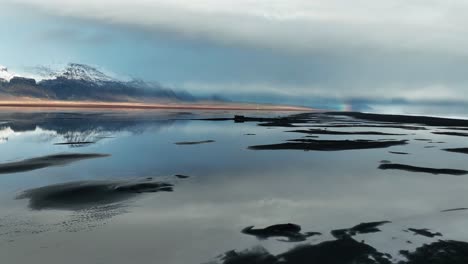 Flying-over-shipwreck-towards-rainbow---south-iceland-coast