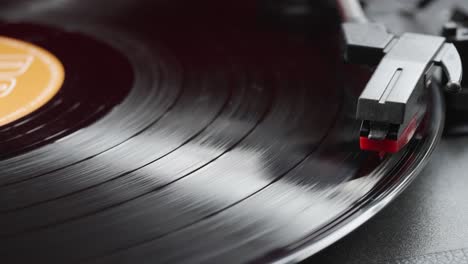 close-up view of spinning black vinyl record and stylus on retro record player
