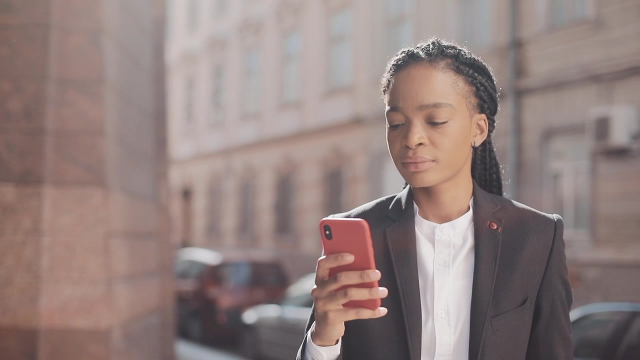 Professional Woman Using Smartphone on City Street