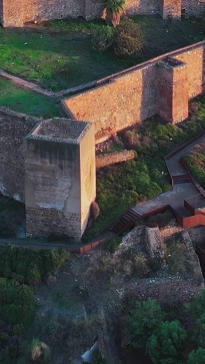 Esplora le storiche mura del castello vicino Malaga, in Spagna, durante il tramonto