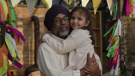 grandfather and granddaughter share a loving hug amidst festive decorations
