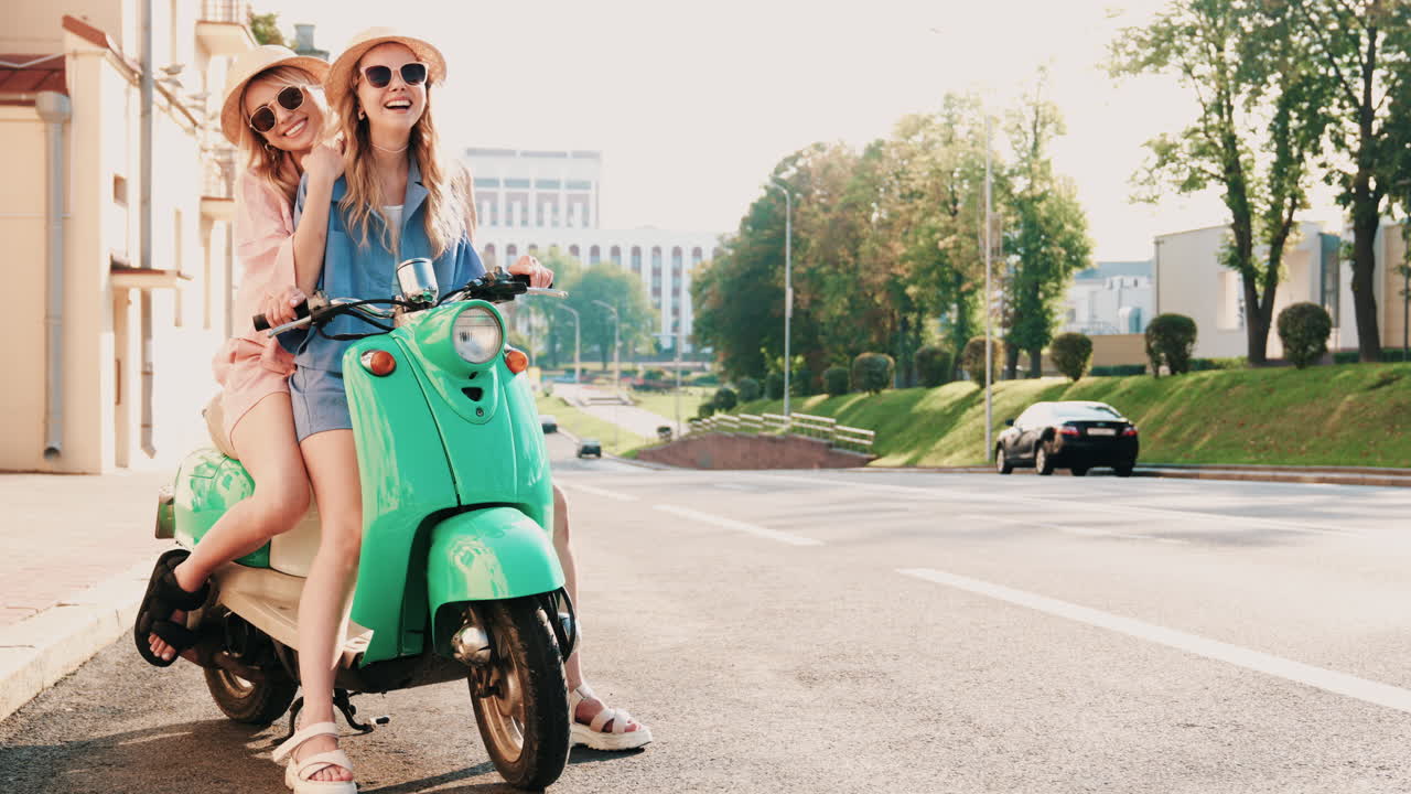 dos mujeres montando un scooter en la ciudad