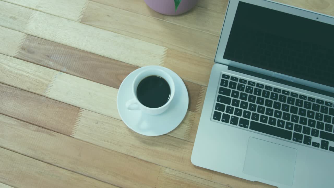 Dotted map overlay appearing on laptop screen by coffee cup, marking pins visualizing connectivity
