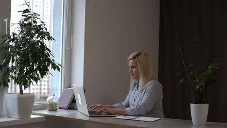 online group video call conference of work team from home office. woman in headphones talks with 4 people at video chat using laptop. self-isolation at covid-19 pandemic. 4k top view medium orbit shot