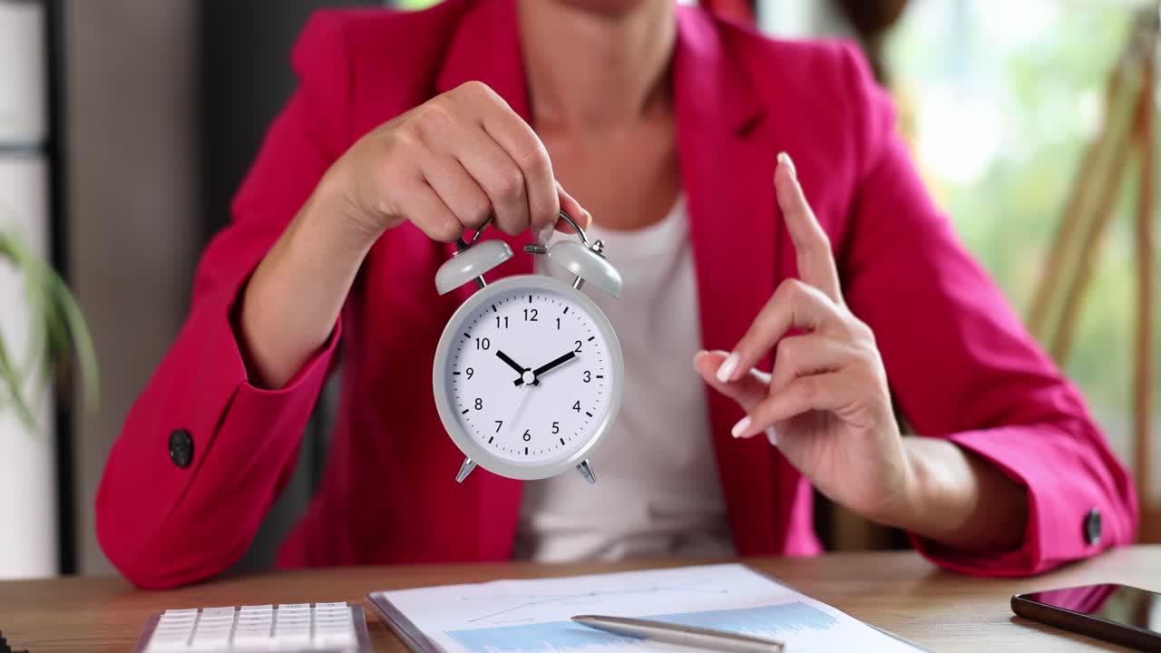 Woman holding alarm clock over business chart