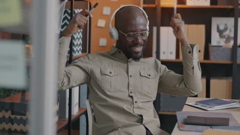 happy man enjoying music in office