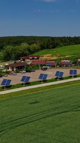 modern complex with photovoltaic cells. row of solar panels along the road in nature landscape. sustainable energy. aerial view. vertical video