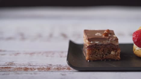 Frische-Hausgemachte-Sahnedesserts-Auf-Einem-Schwarzen-Teller,-Nahaufnahme,-Folie