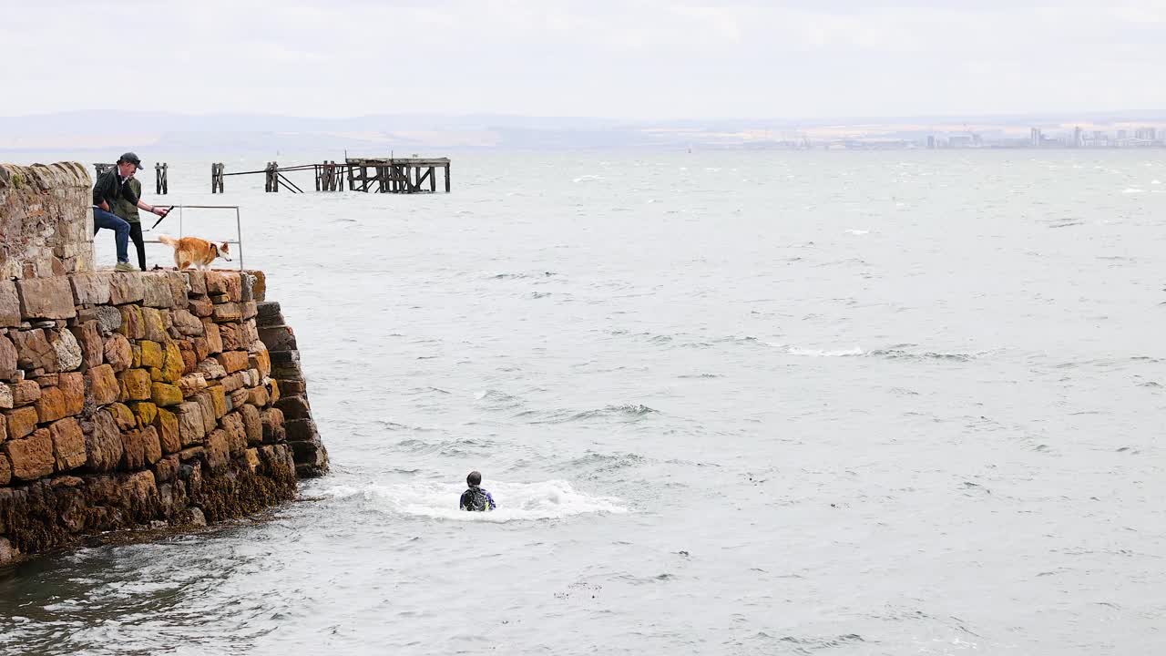 한 무리의 사람들이 바다로 뛰어들고 있습니다.