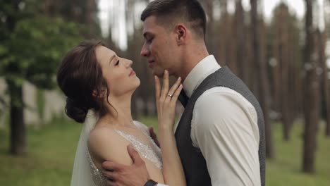 newlyweds, caucasian groom with bride walking, embracing, hugs in park, wedding couple