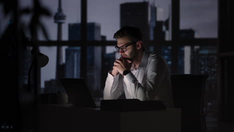 Retrato-De-Un-Hombre-De-Negocios-Exitoso-Y-Reflexivo-Que-Trabaja-En-Una-Computadora-Portátil-En-Su-Oficina-De-La-Gran-Ciudad-Por-La-Noche.-Carismático-Emprendedor-Digital-Realiza-Análisis-De-Datos-Para-Estrategia-De-Comercio-Electrónico.