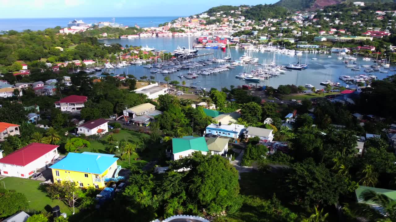 Real estate aerial of hillside property overlooking picturesque sea harbor with boats and yachts