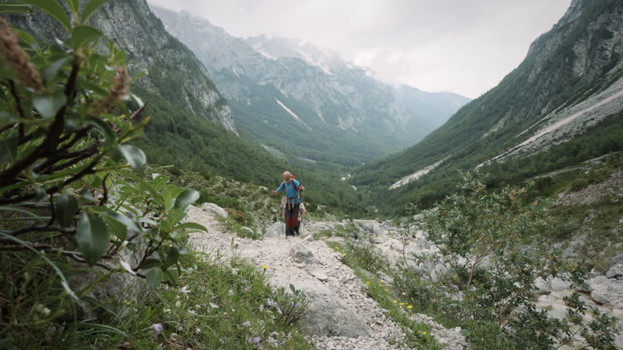 excursionistas acercándose desde el valle, caminando lentamente hacia la cámara