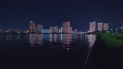 Luz-Nocturna-Tokio,-Tsukuda,-Rascacielos-Toyosu-Y-Puente-Sobre-El-Río-Sumida-Yakatabune,-Embarcación-De-Recreo