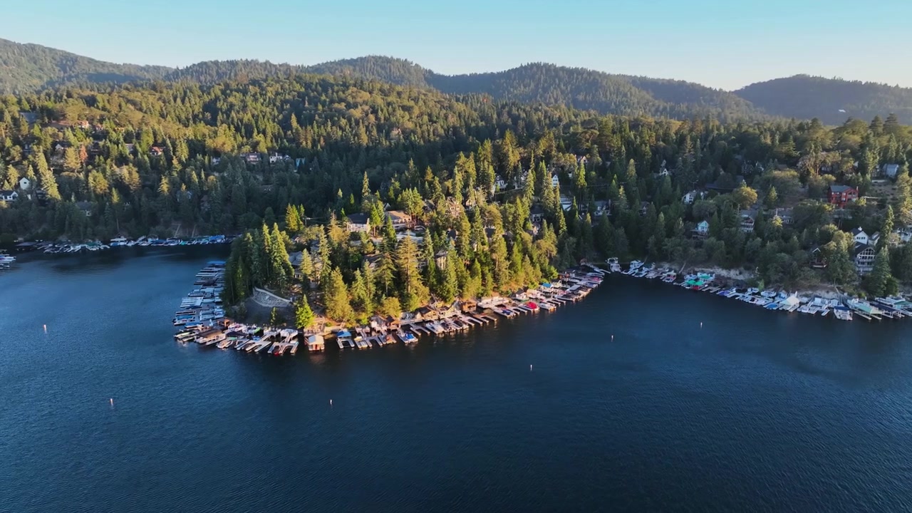 Panoramisk droneoptagelse med udsigt over søbredden ved Lake Arrowhead, solnedgang i Californien.