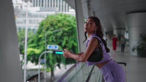woman in purple outfit on a city bridge