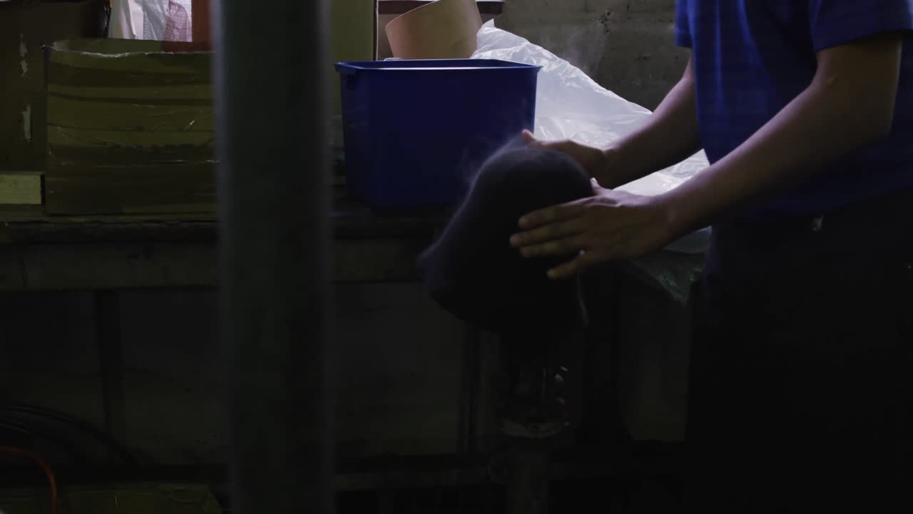 모자 공장에서 일하는 혼성 인종의 남자