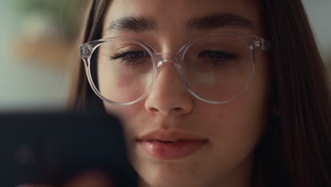 close up of caucasian teenage girl browsing phone while sitting on bed