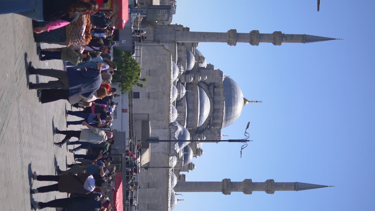 Bustling crowd in front of the Yeni Cami Mosque in Istanbul, Turkey on a sunny day