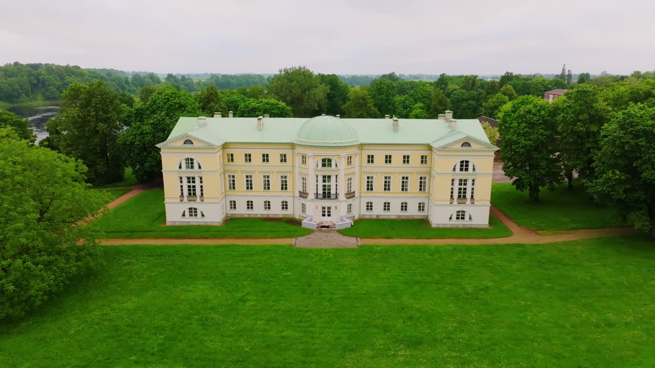 Aerial establishing shot reveals palace symmetry amid lush summer greenery