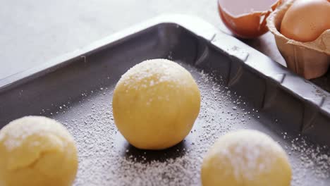 bolas de masa con azúcar de glaseado en la bandeja de horneado 4k