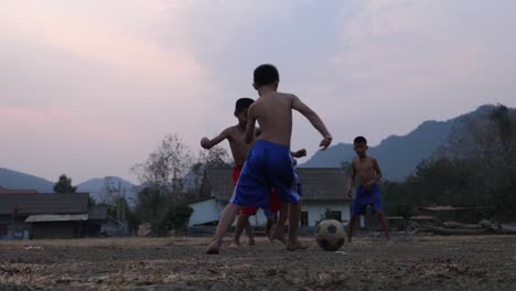children playing soccer in a rural village