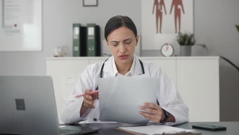 Stressed-Indian-female-doctor-checking-medical-reports