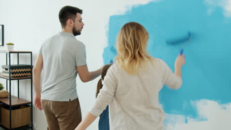family painting a wall blue