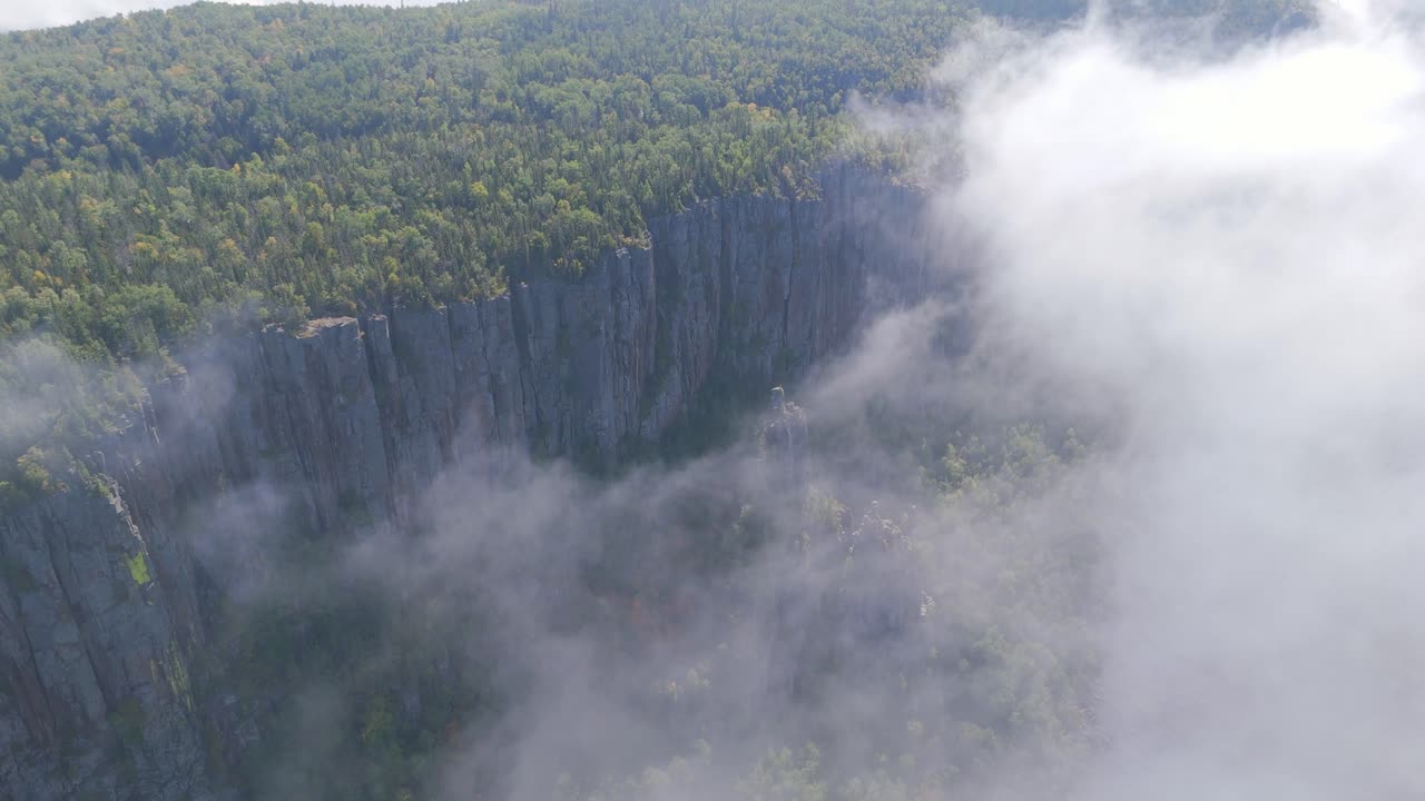 A breathtaking aerial view of Sleeping Giant, Ontario, partially veiled in soft morning fog drifting over the rugged cliffs