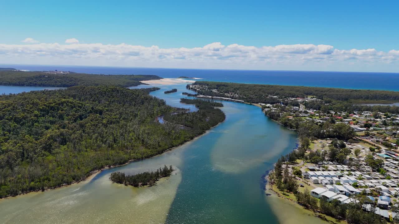 Orbita aerea a destra del corso d'acqua del lago Conjola, circondato dalla foresta e dalle case vicine