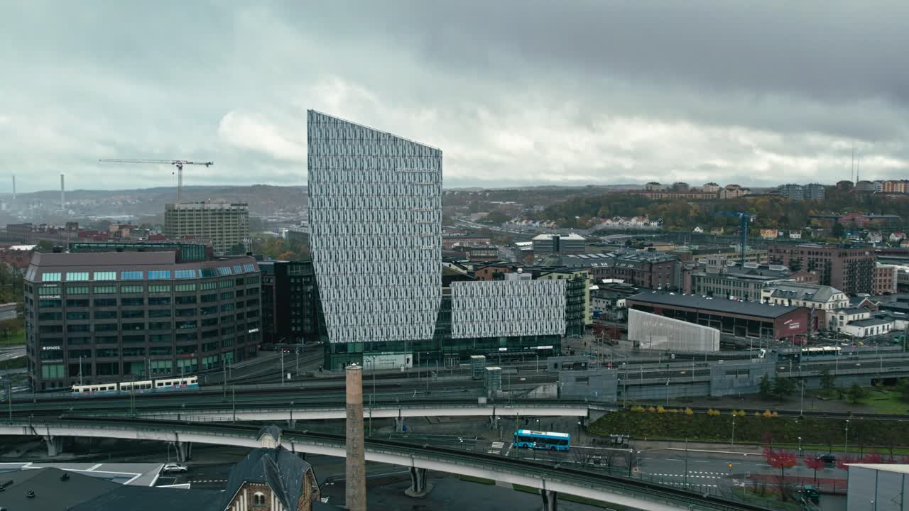 Giorno nuvoloso a Gamlestaden, Göteborg, con scena di pendolari urbani.