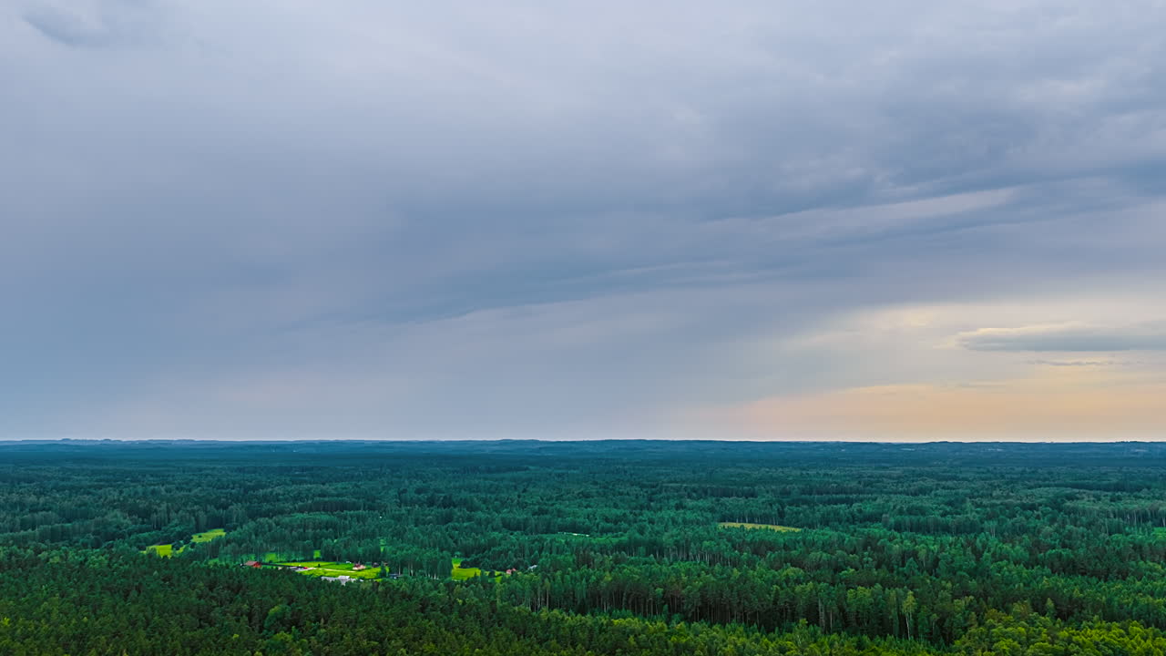 View of fast-moving clouds above a dense forest on a cloudy day