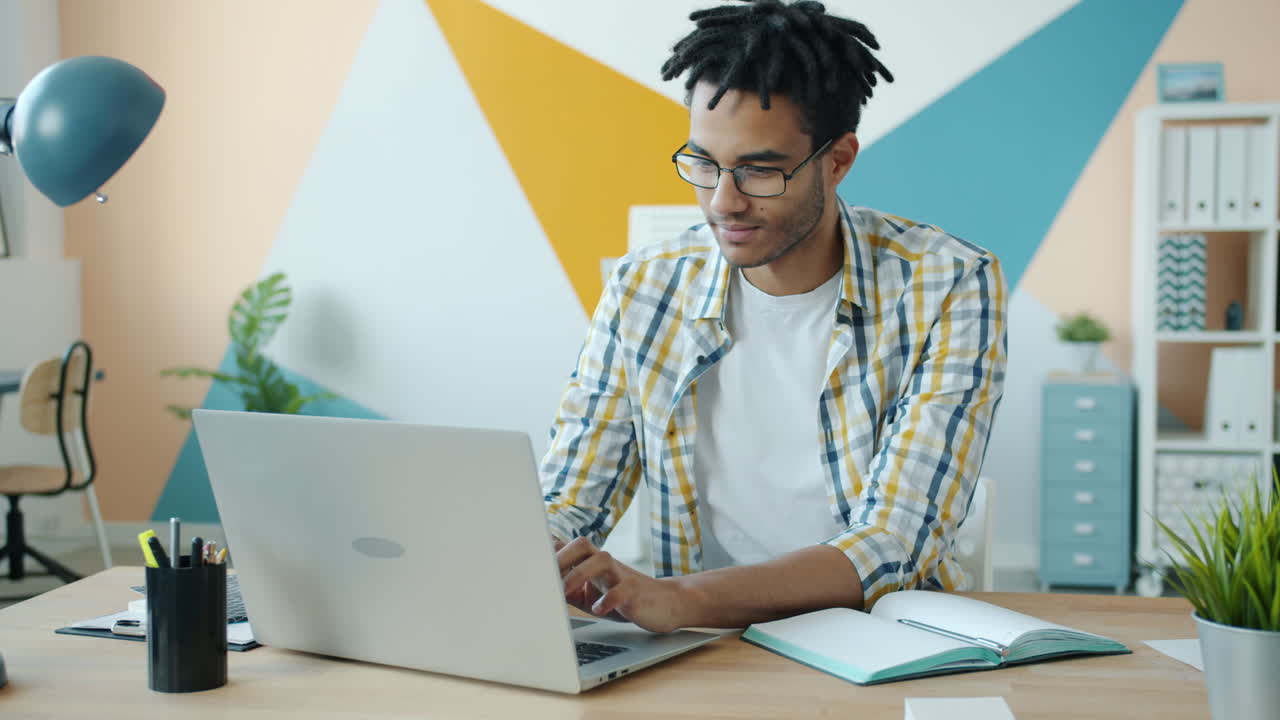 Young Man Working on Laptop in Modern Office