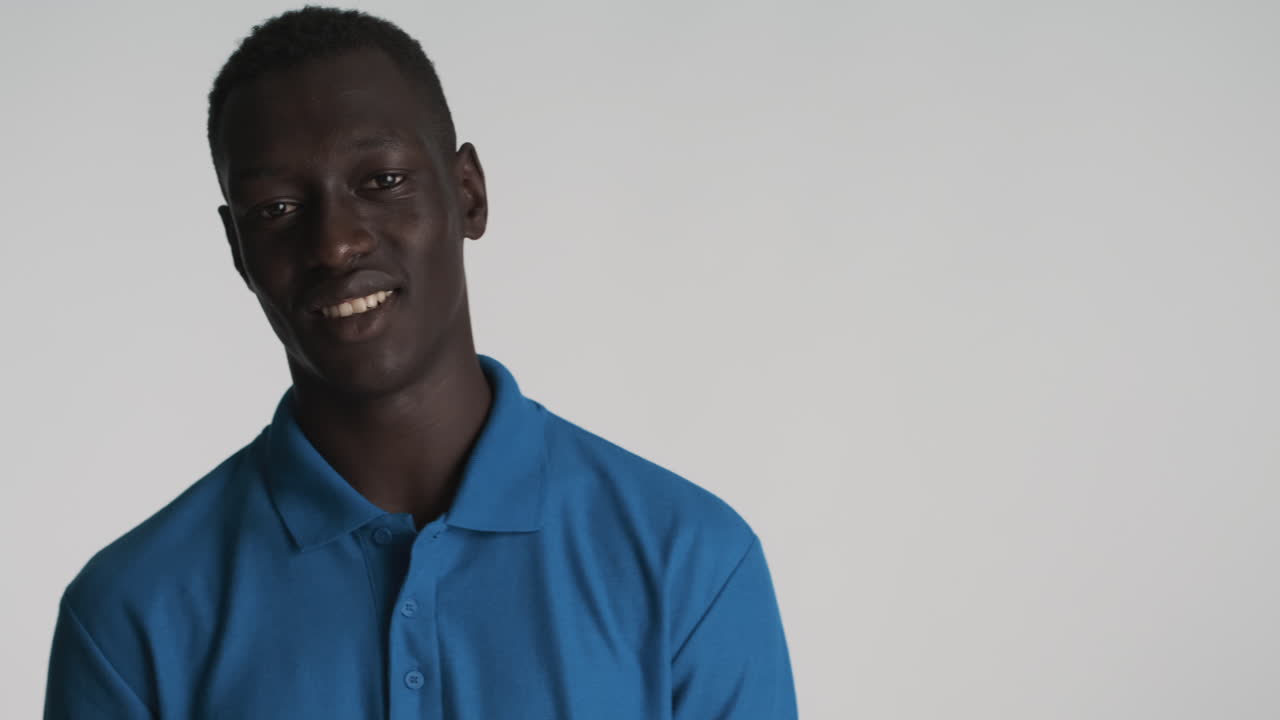 um homem afro-americano feliz com fundo cinzento.