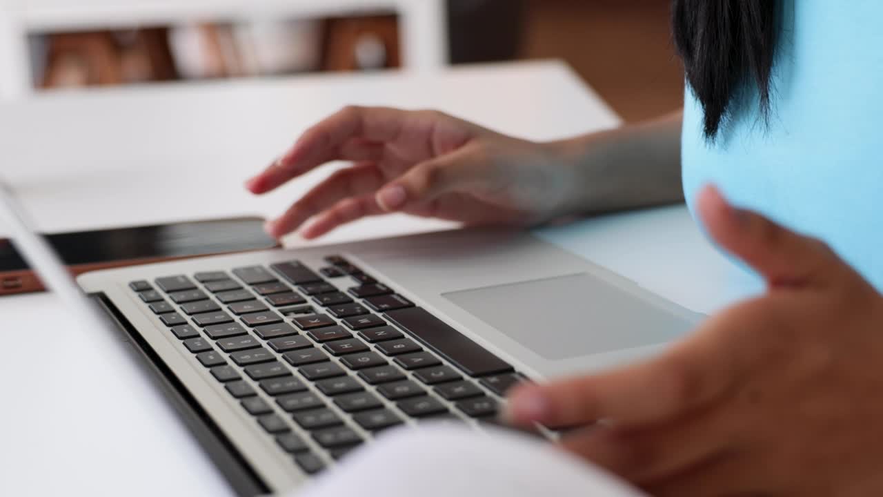 Asian young teenage woman use and typing on laptop computer at library of school. University Library education and Student Learning concept.