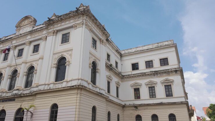 Edificio governativo storico a Casco Viejo, Panama City, con palme e sfondo di cielo blu.