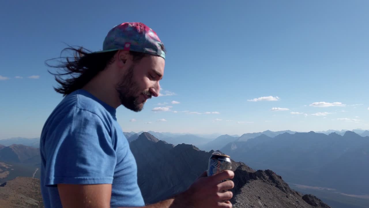 excursionista bebiendo cerveza en el pico de la cordillera rocosa cerca de kananaskis alberta frontera de columbia británica canadá