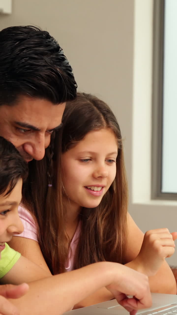 Padre che usa il laptop con i suoi figli