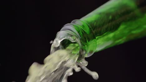 clear liquid emanating from green glass bottle