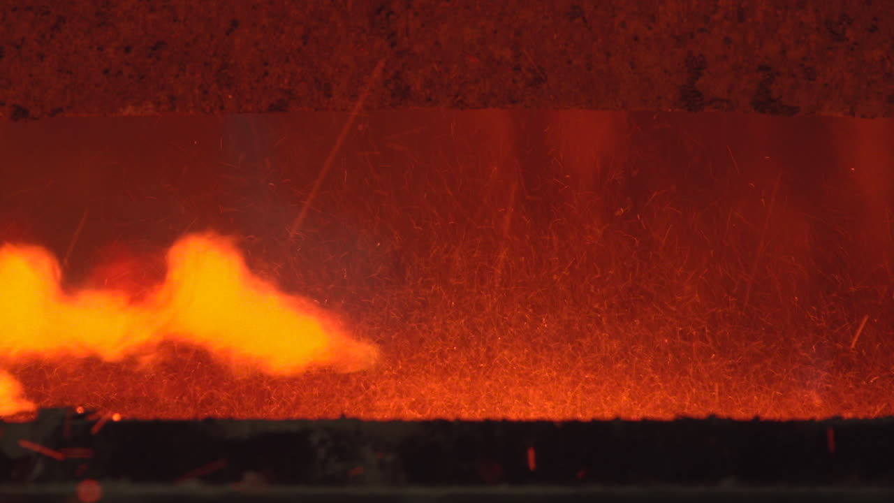 Bright Orange Flames and Flying Sparks Inside a Hot Industrial Furnace