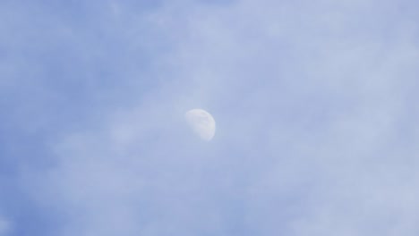 daytime moon with passing clouds slowly in tiemalapse shot