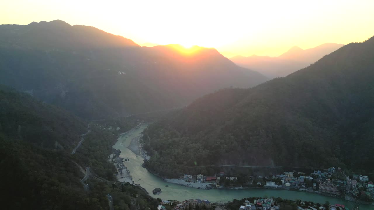 early morning beautiful sunrise behind the mountains and Ganga river flowing in Rishikesh done closer to wide view in india