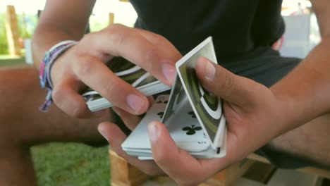 portugal - young man doing card tricks with his hands while sitting - close-up shot