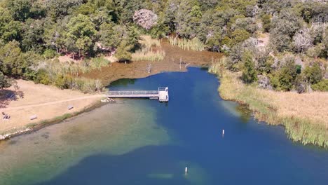 un tiro ancho de un arco lento en sentido contrario a las agujas del reloj alrededor de un muelle de pesca en una pequeña entrada en el lago