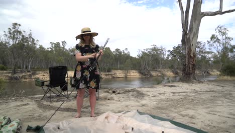 Blonde-Frau-Packt-Zelt-Australien-Camping-Pflöcke-Und-Stangen