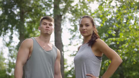 Porträt-Eines-Sportlichen-Jungen-Paares,-Das-In-Einem-Wald-In-Die-Kamera-Schaut